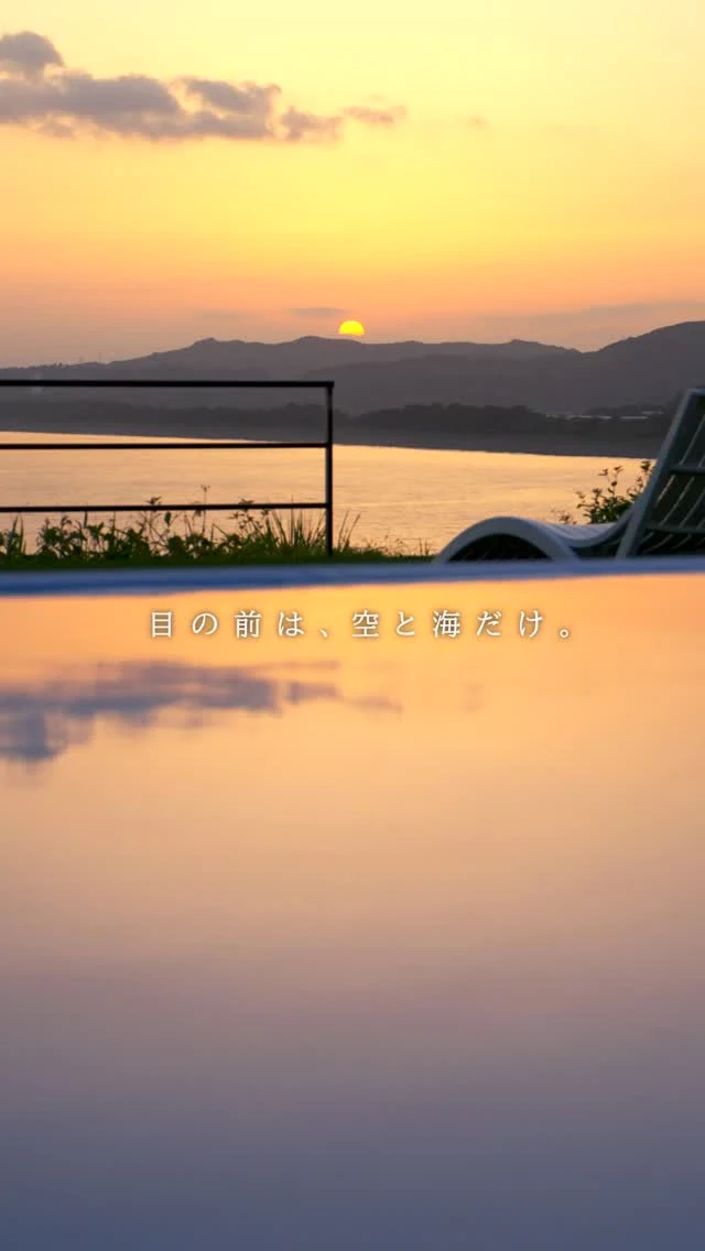 プール越しに夕日が沈むYUHIMIの風景